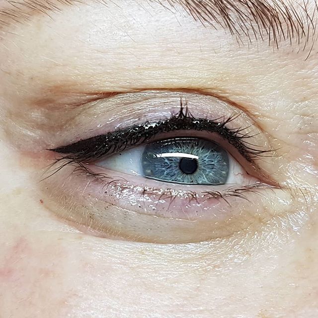 Eine Nahaufnahme des blauen Auges einer Frau mit Eyeliner.