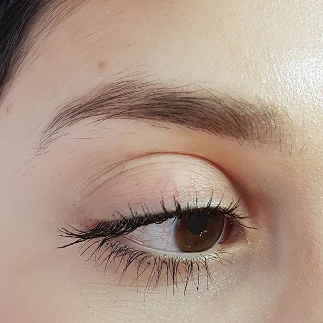 Eine Nahaufnahme des Auges einer Frau mit langen Wimpern.