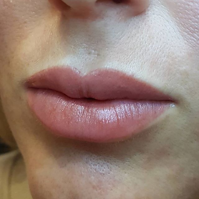 Eine Nahaufnahme der Lippen einer Frau mit rosa Lippenstift.