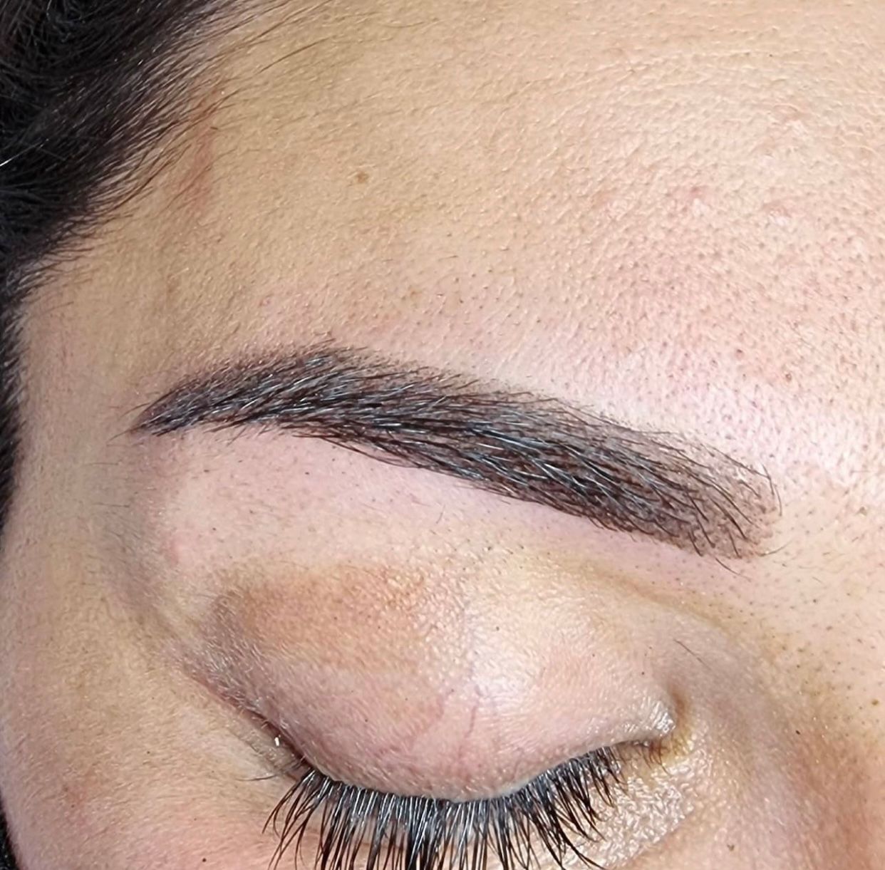 Eine Nahaufnahme der Augenbrauen einer Frau mit geschlossenen Augen.