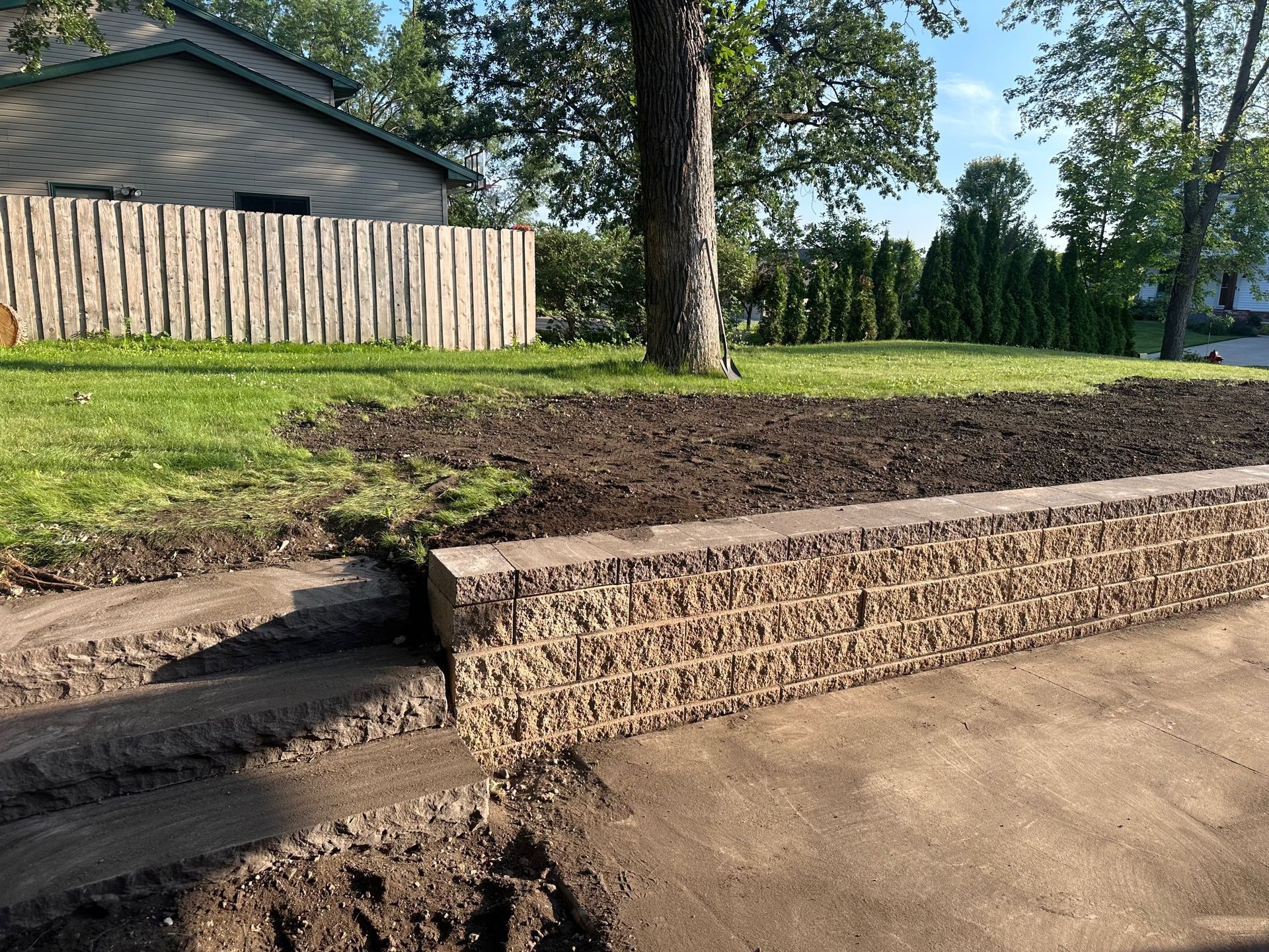 A brick wall is being built in front of a house. A brick wall is being built in front of a house.