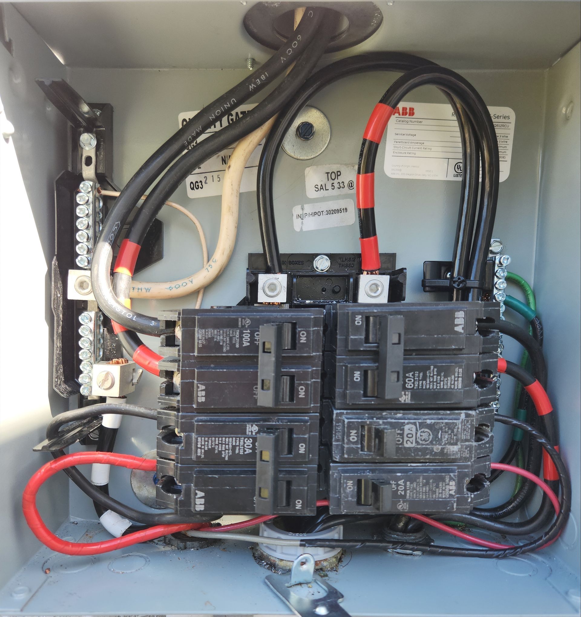 Electrical panel with multiple circuit breakers and wiring connections.