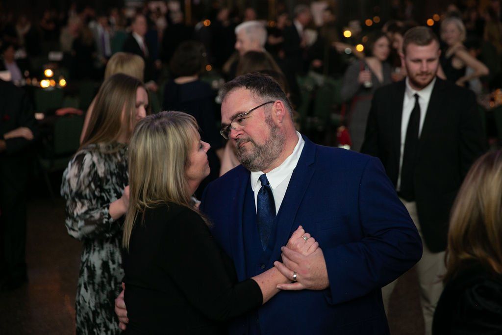 A man and a woman are dancing together at a party.