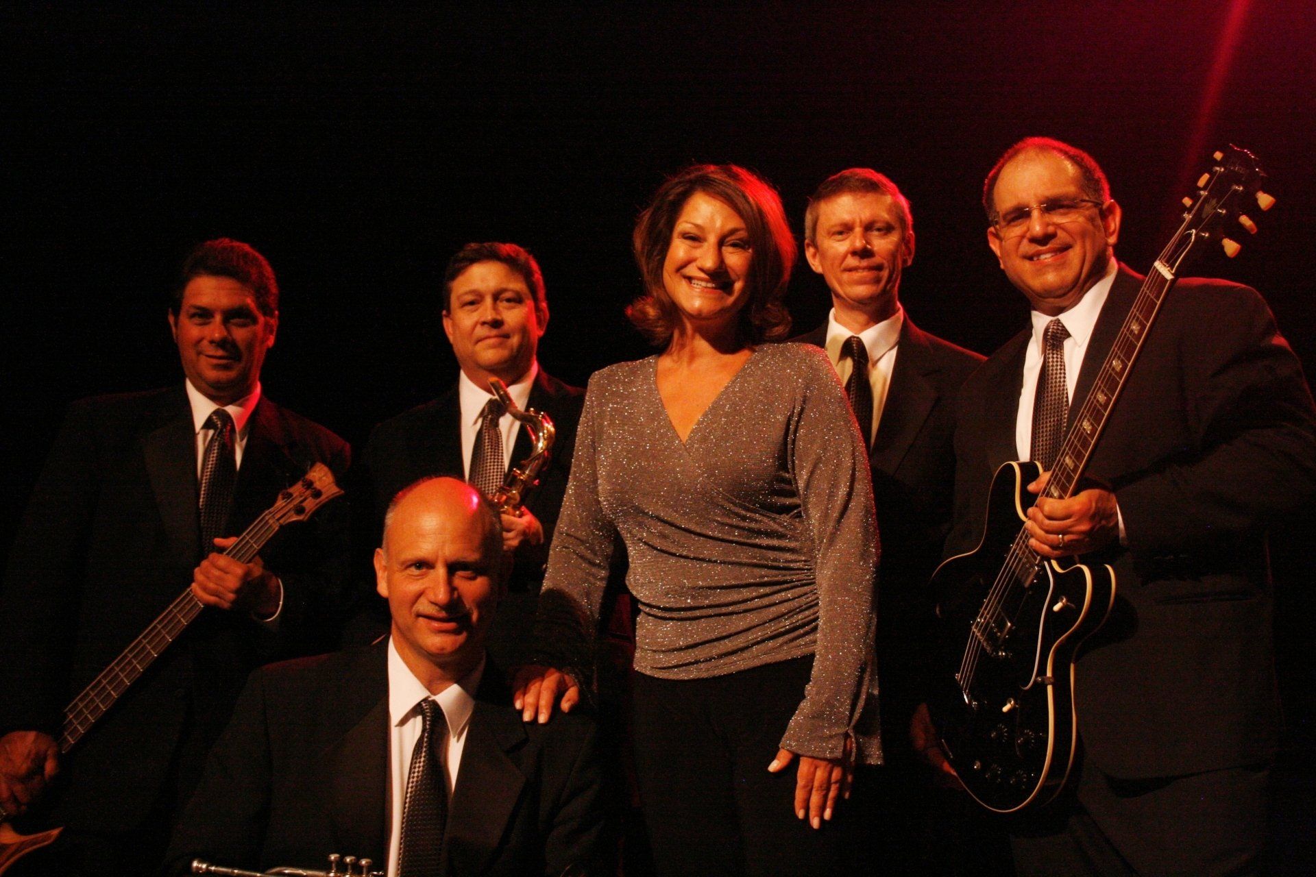 A group of men and a woman are posing for a picture