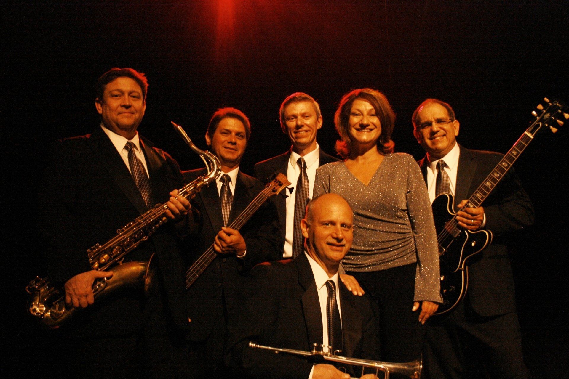 A group of musicians are posing for a picture with their instruments
