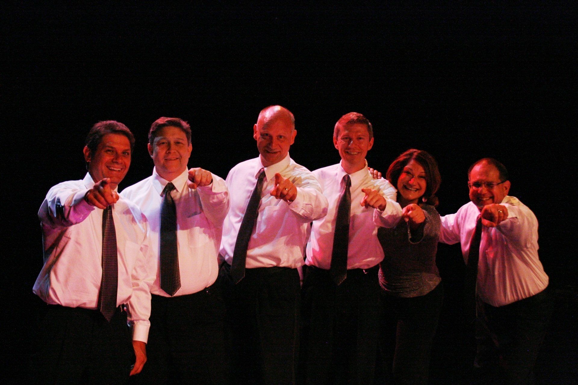 A group of men and women pointing at the camera