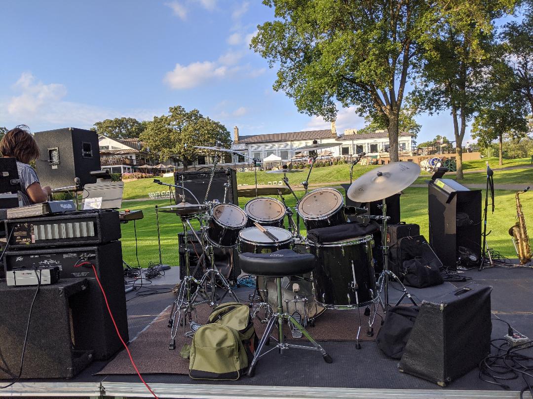 A drum set is sitting on top of a stage in a park.