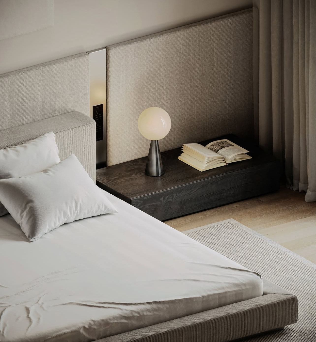 Dormitorio con cama, mesita de noche, lámpara y libros; colores neutros, diseño minimalista.