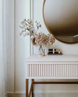 Dormitorio adornado con cama grande sobre piso cubierto de musgo, debajo de pintura, rodeado de plantas y una gran ventana.