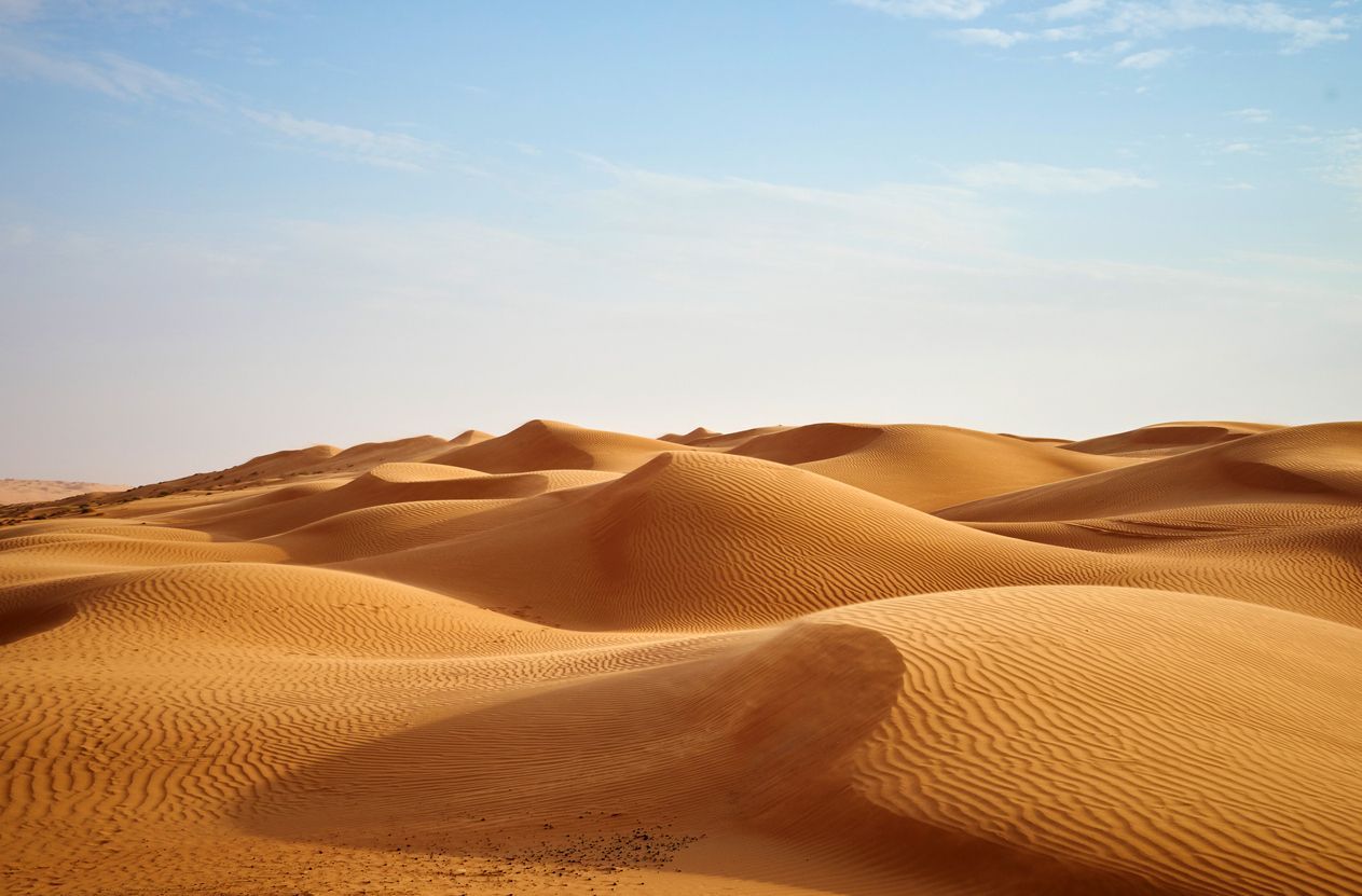 Golden sand dunes under a clear blue sky.