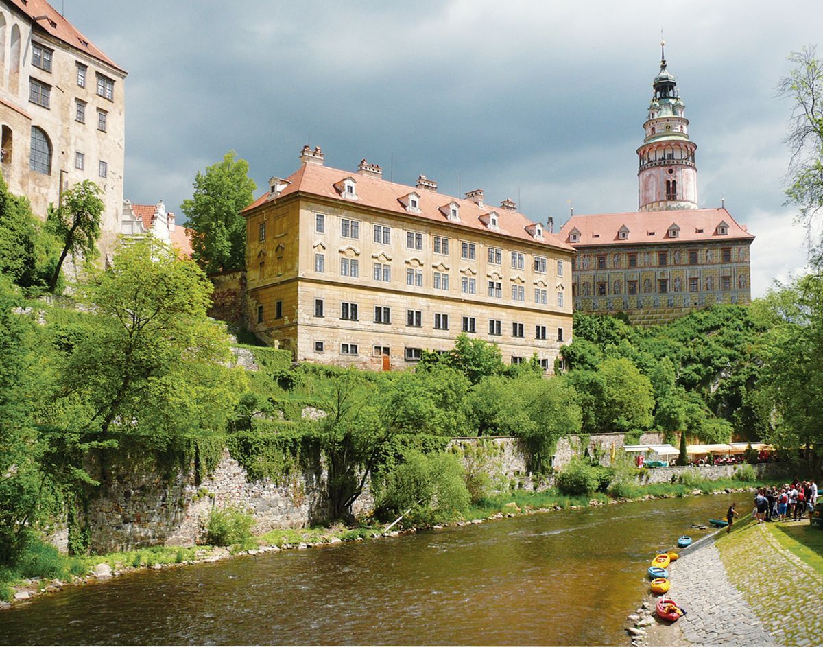 Velká budova s ​​hodinovou věží je u řeky.