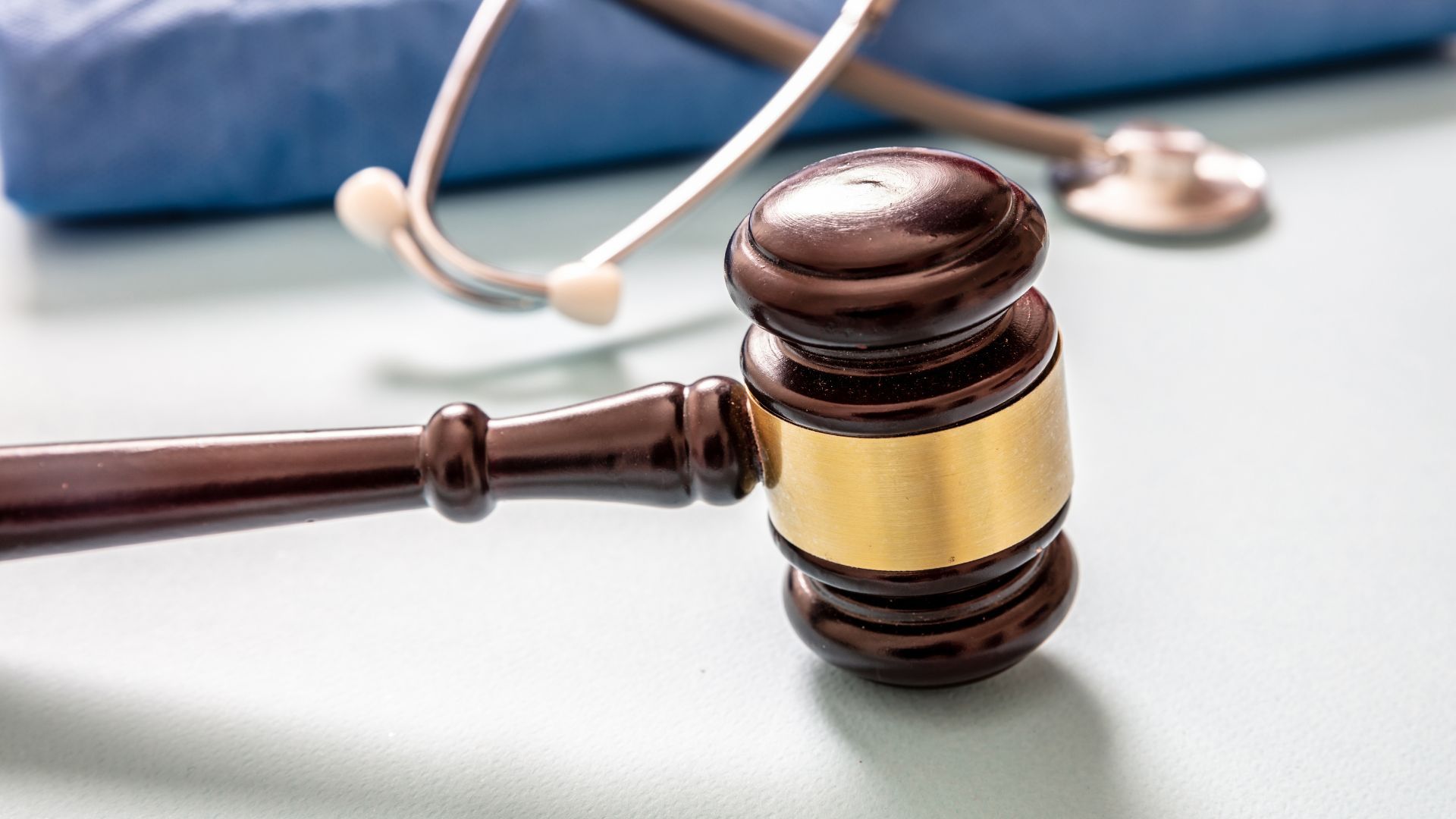 A wooden judge 's gavel with a stethoscope in the background