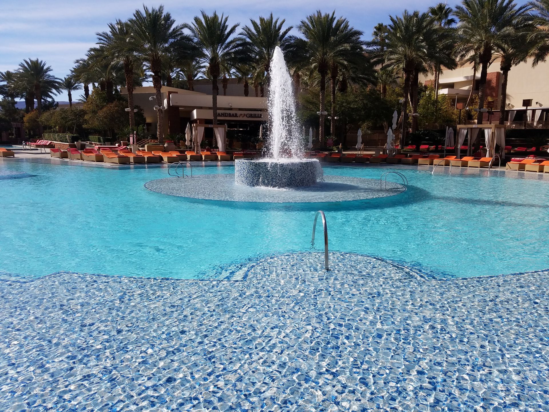 A large swimming pool with a fountain in the middle
