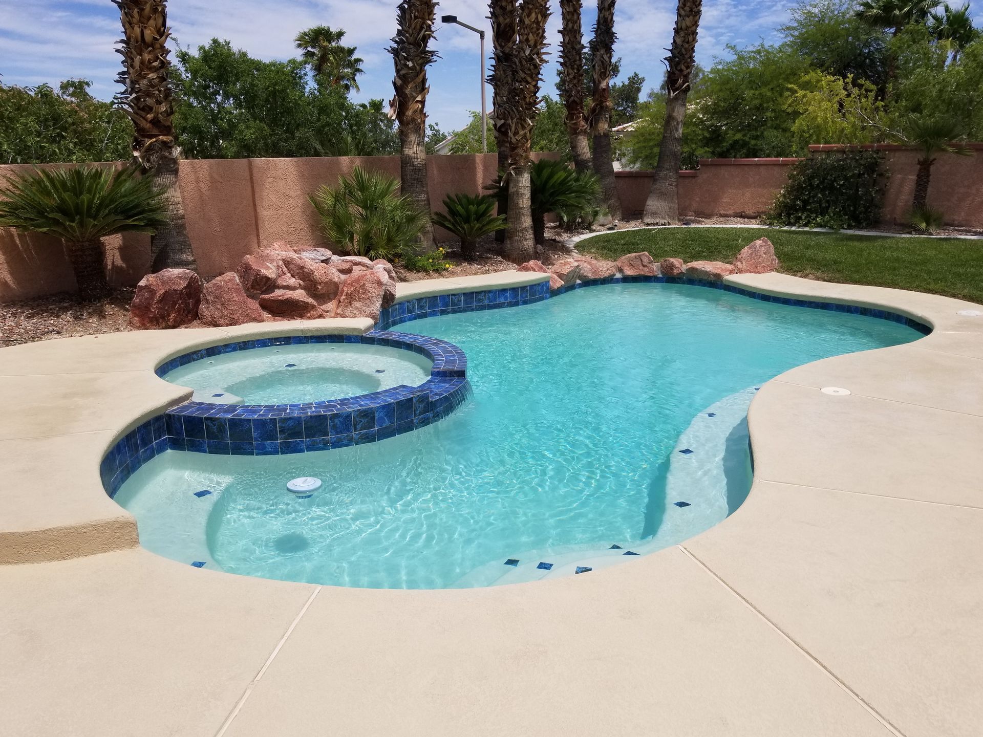 A large swimming pool with a hot tub in the middle