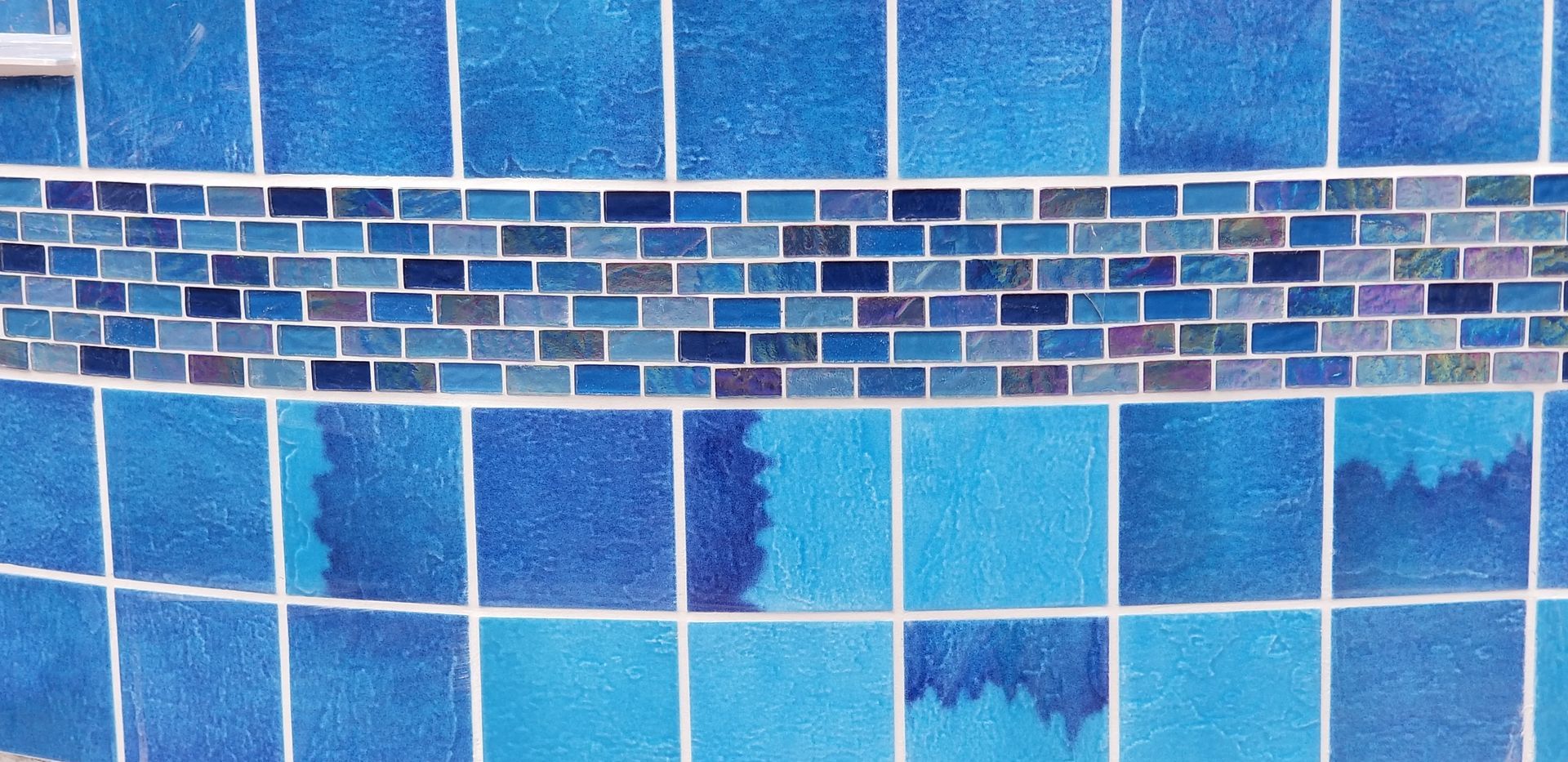 A close up of a blue tile wall in a swimming pool.
