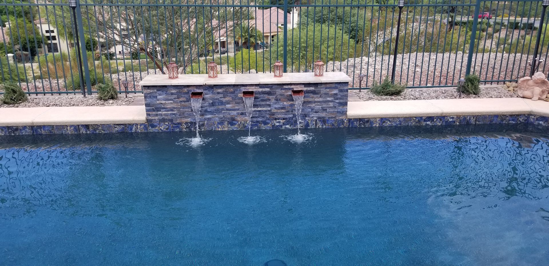 A large swimming pool with a waterfall in the middle of it.