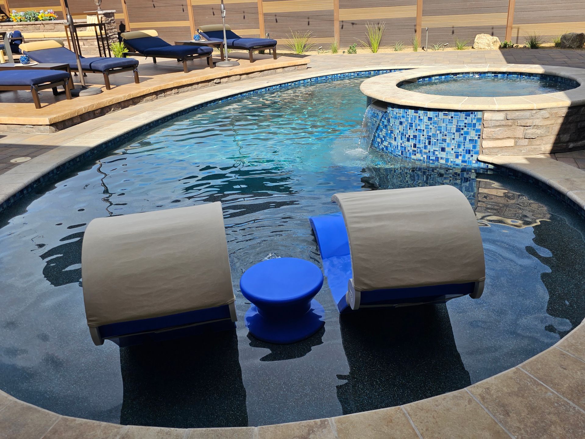 A large swimming pool with two chairs in it