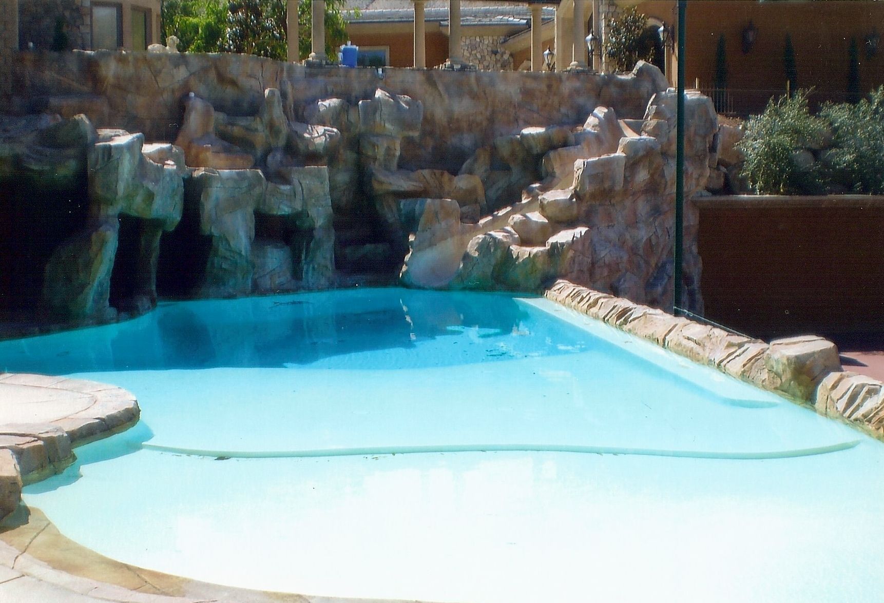 A large swimming pool with a waterfall in the background