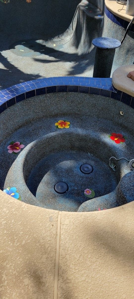 A close up of a hot tub with flowers in it.