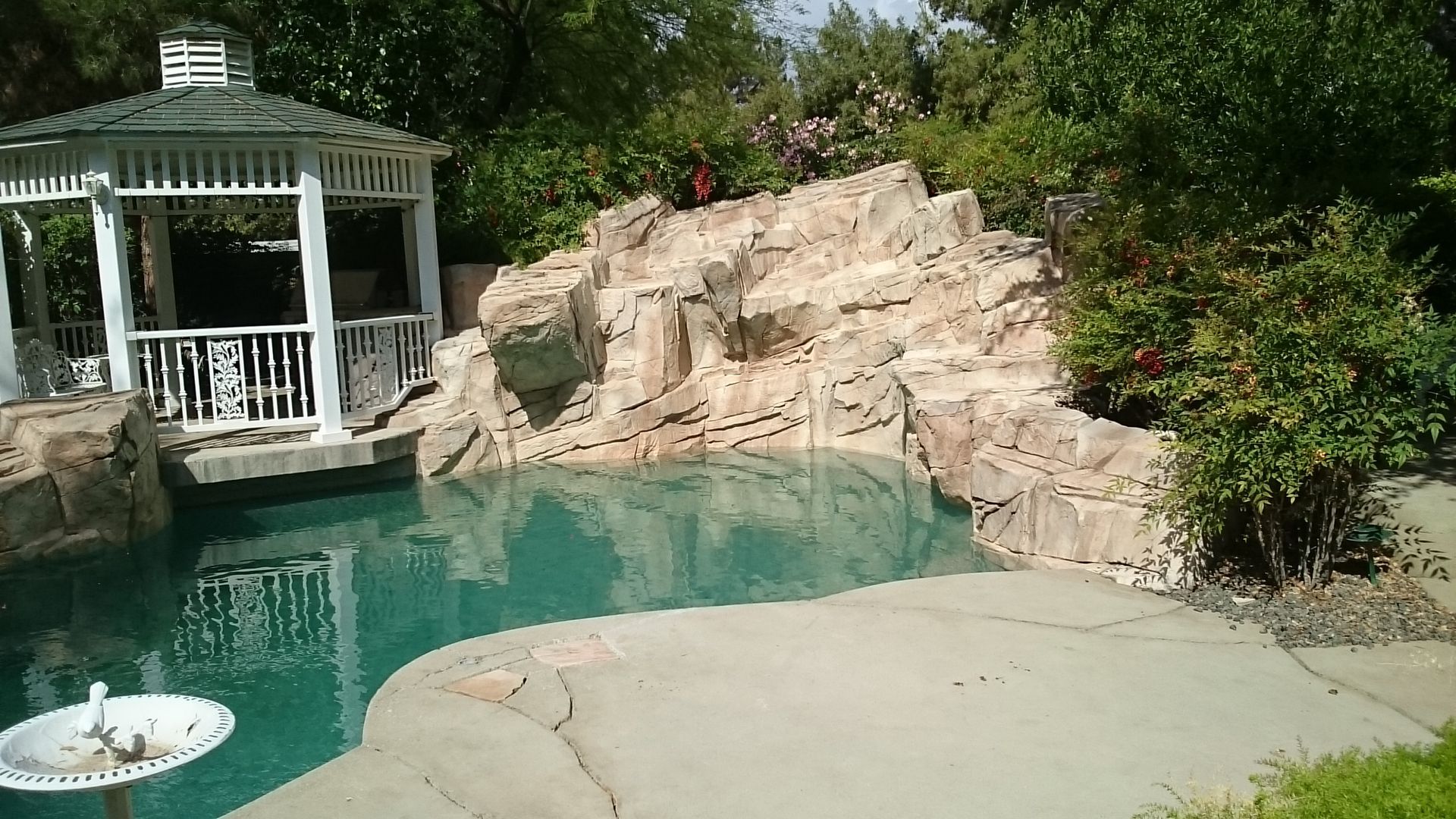 There is a gazebo in the middle of a swimming pool.