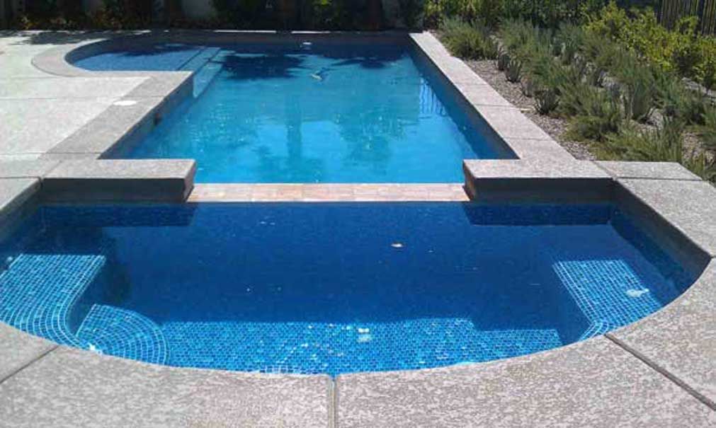 A large swimming pool with a smaller pool in the middle