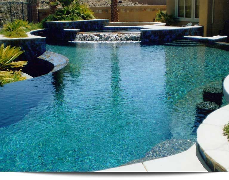 A large swimming pool with a waterfall in the middle