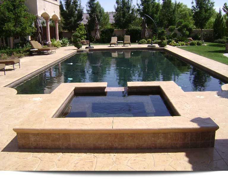 A large swimming pool with a hot tub in the middle