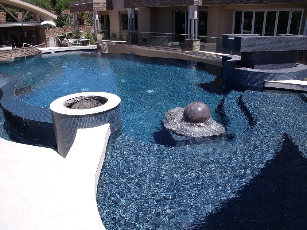 A large swimming pool with a fountain in the middle