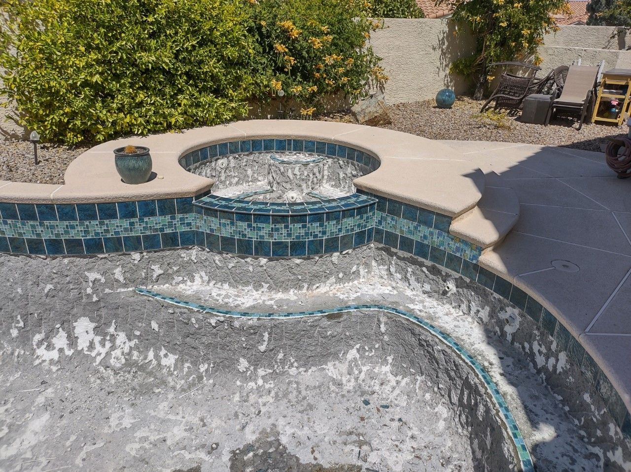 A swimming pool with a hot tub in the middle of it