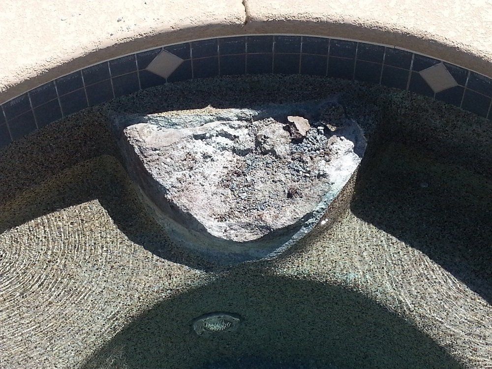 A large rock is in the middle of a pool