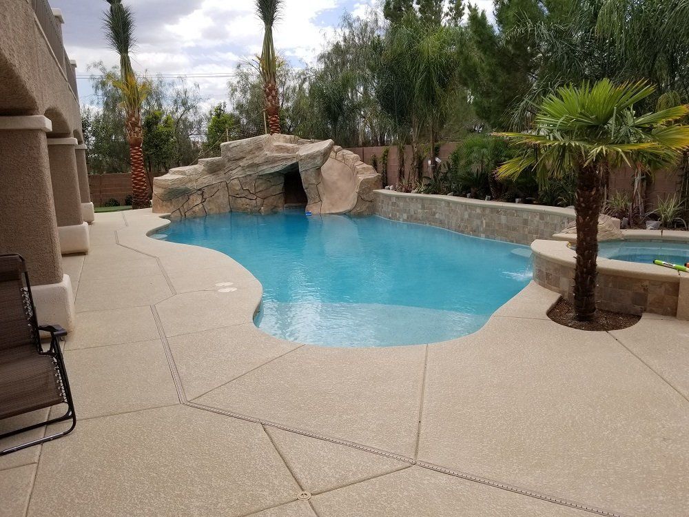 A large swimming pool with a water slide and palm trees