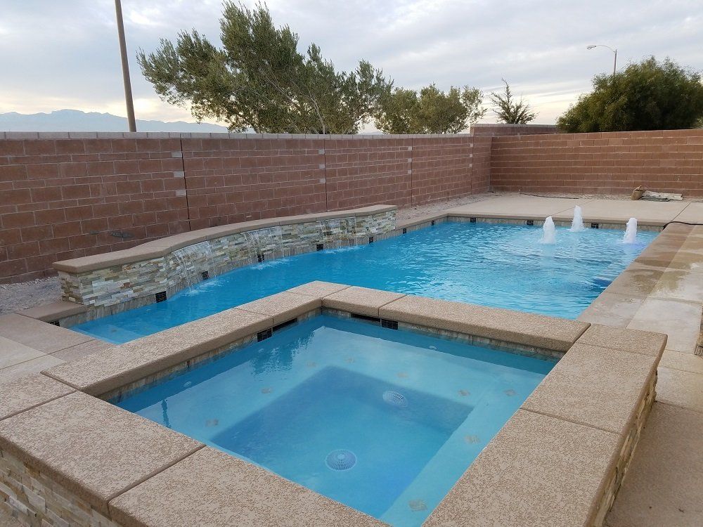 A large swimming pool with a hot tub in the middle