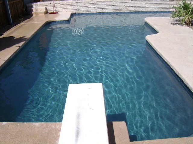 A large swimming pool with a diving board in the middle