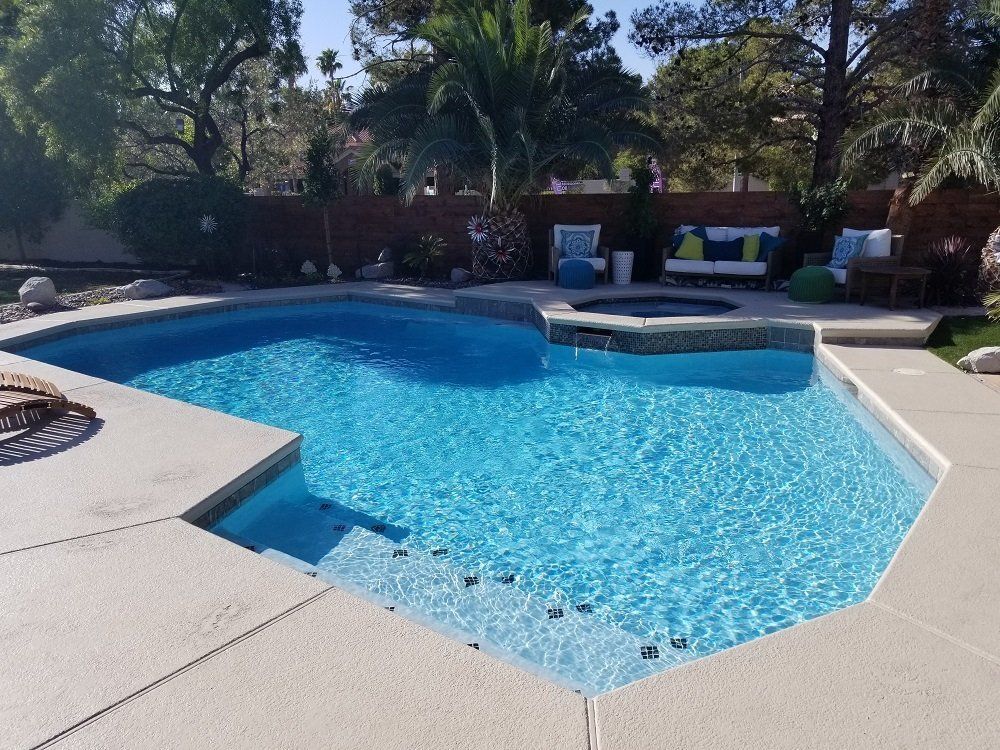 A large swimming pool with a hot tub in the middle