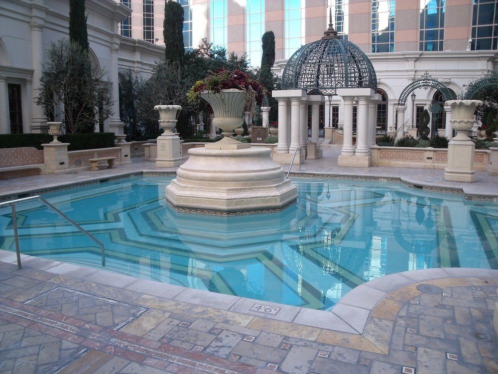 A large swimming pool with a fountain in the middle
