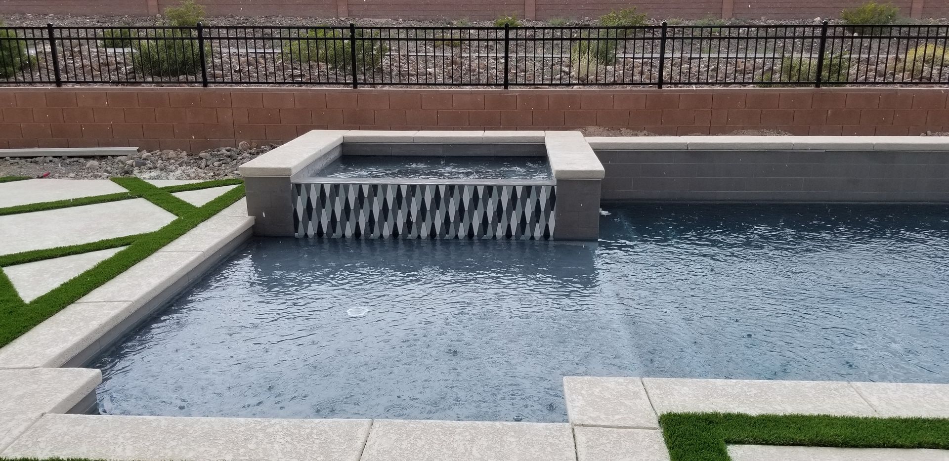 A swimming pool with a waterfall in the middle of it