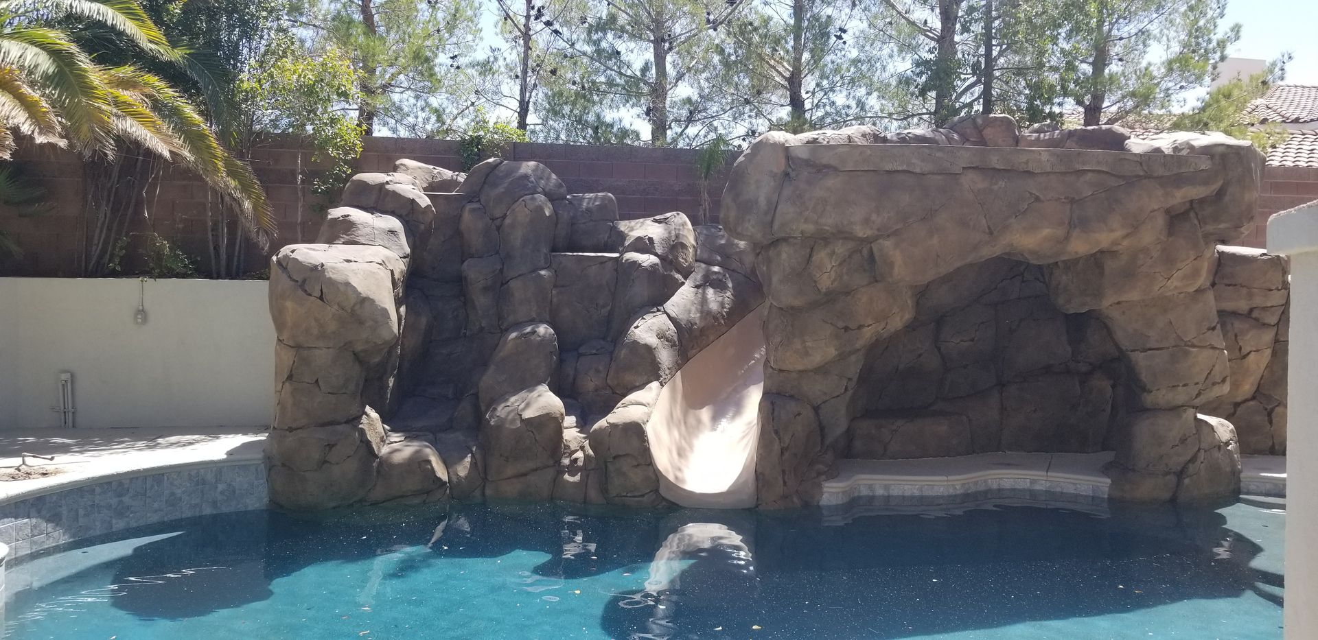 A swimming pool with a water slide in the middle of it