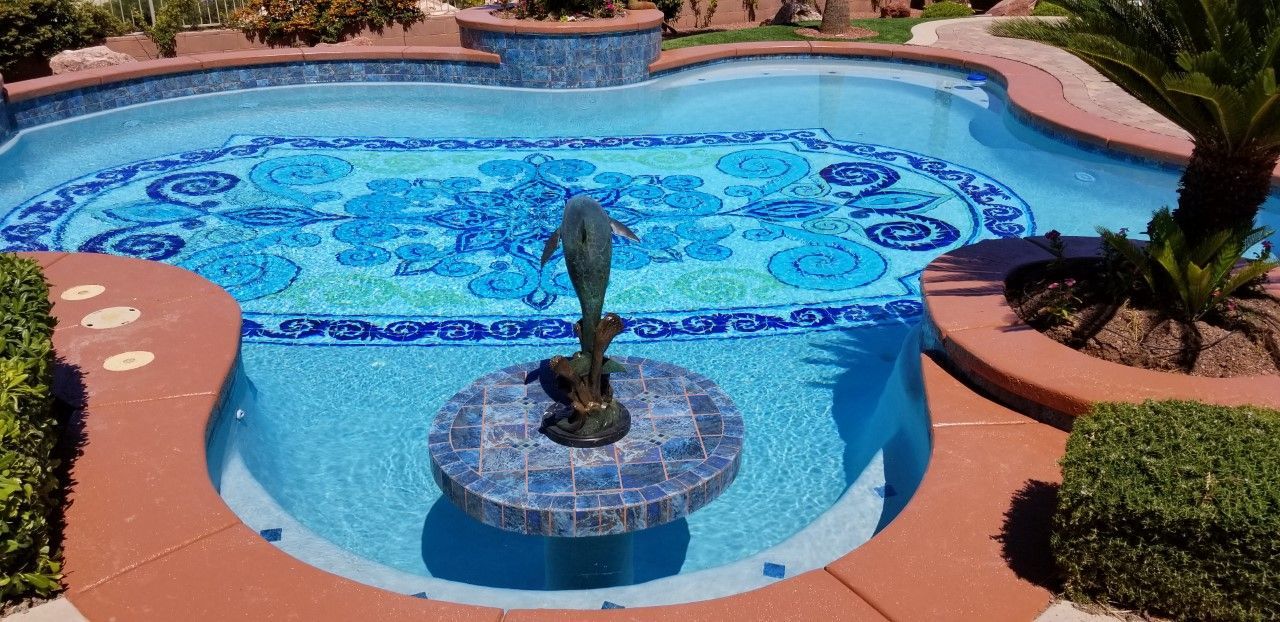 A large swimming pool with a fountain in the middle of it.