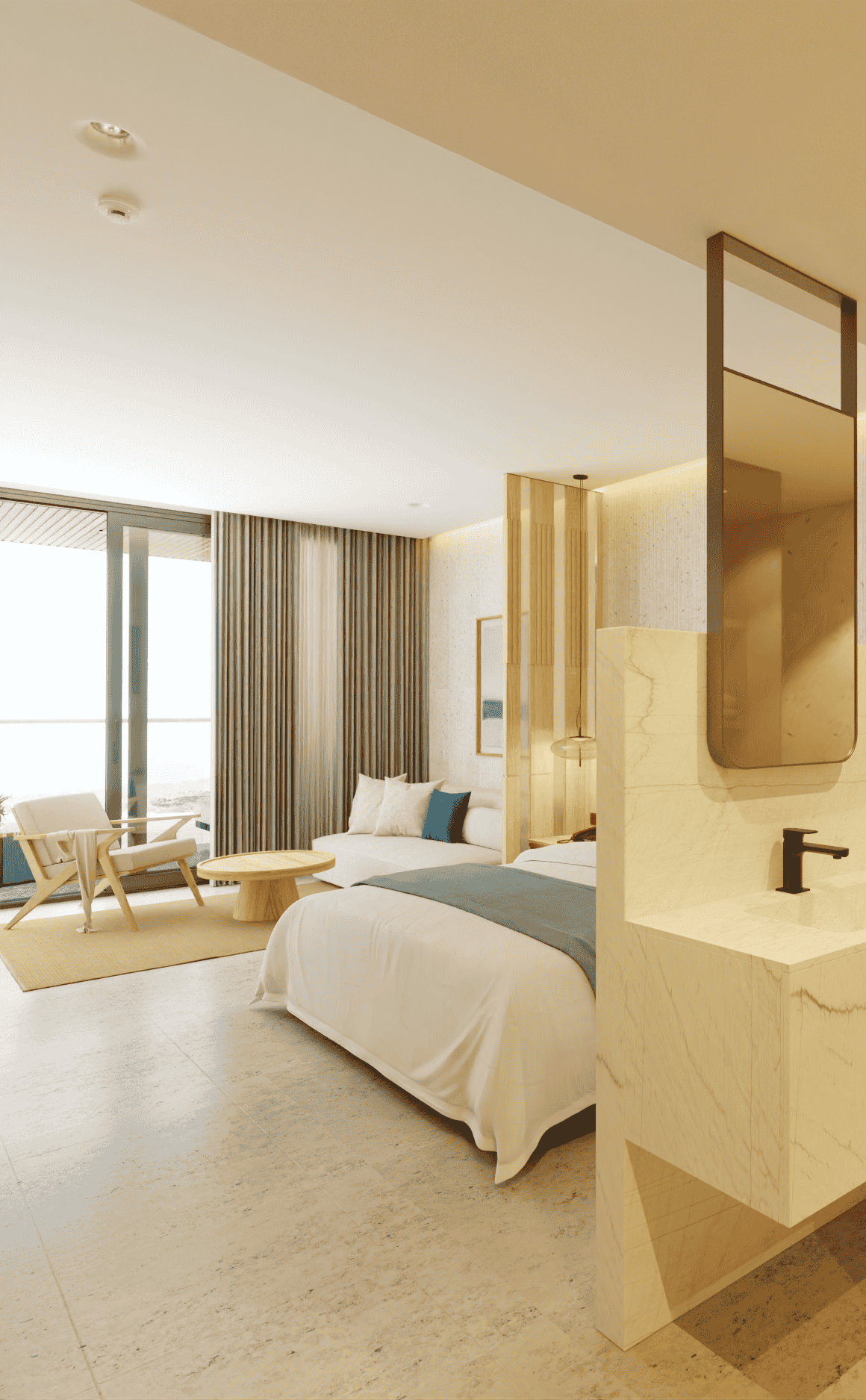 Bright hotel room with bed, seating area, and open bathroom, featuring light colors and ocean view.