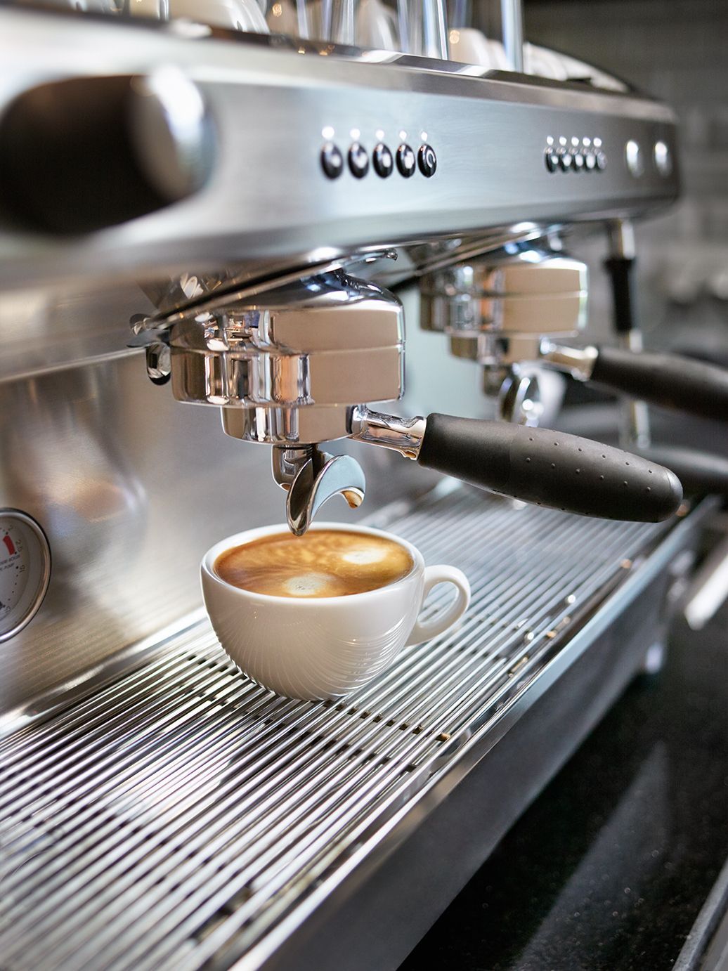 Overhead view of a cafe seating area, featuring a table with treats, a woven chair, and a couch with blue patterned pillows.