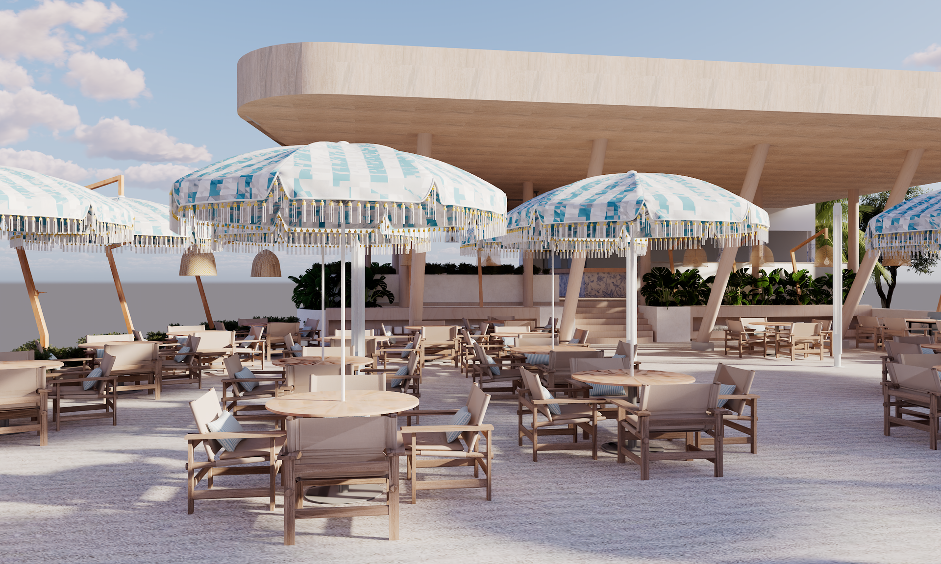Patio furniture on a veranda overlooking the ocean; wooden chairs with blue and cream pillows.
