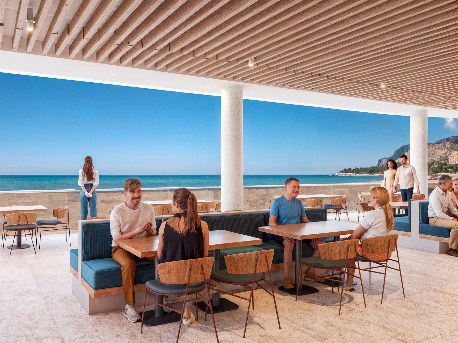 People dining at an outdoor restaurant with ocean view. Blue accents, wooden chairs, and a bright sunny day.