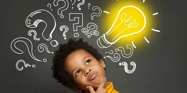 Young boy thinking with illustrations of question marks and a glowing light bulb above his head.