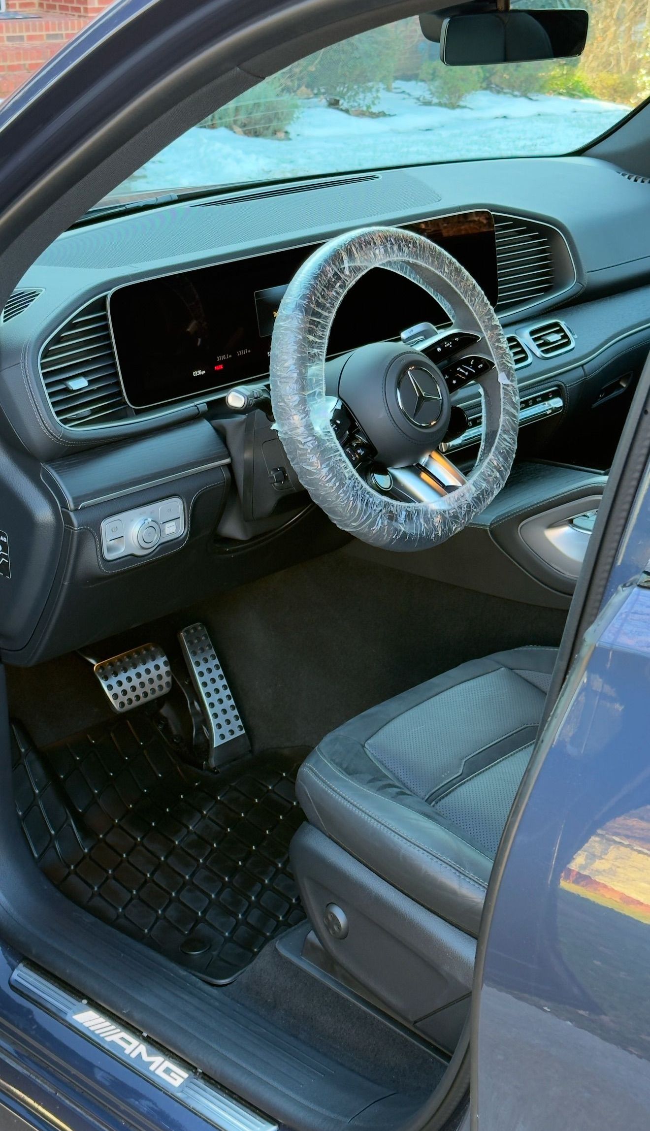 The interior of a blue car with a steering wheel covered in rhinestones.