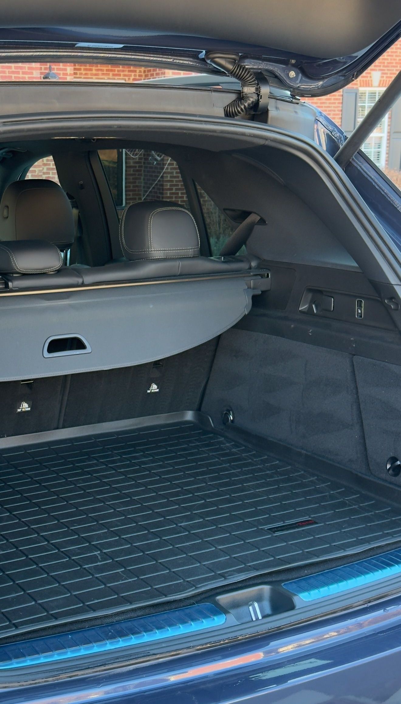 The back of a blue car with the trunk open.