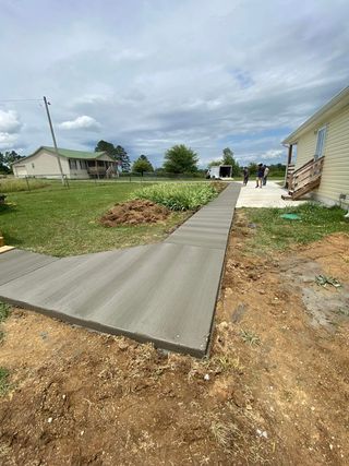 A concrete walkway is being built in front of a house.