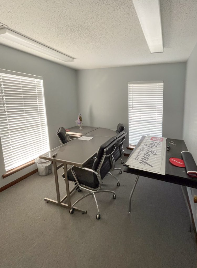 a conference room with a table , chairs , and blinds .