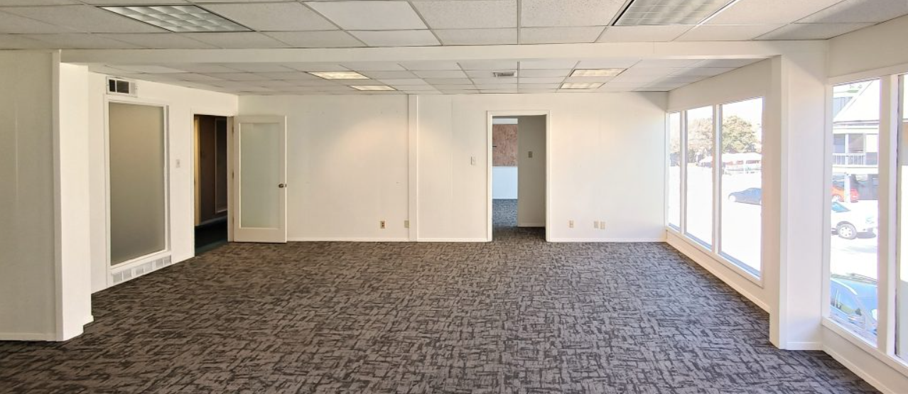 a large empty room with a lot of windows and carpet .