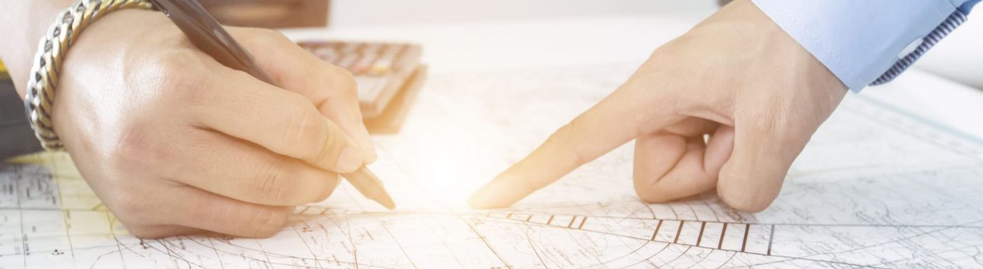 a couple of people are looking at a drawing and pointing at it .