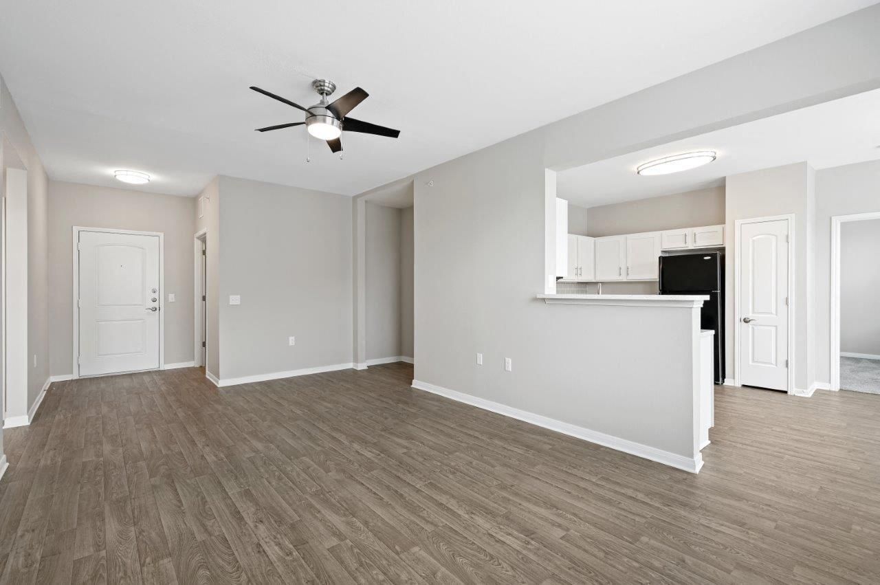 A living room with hardwood floors and a ceiling fan.